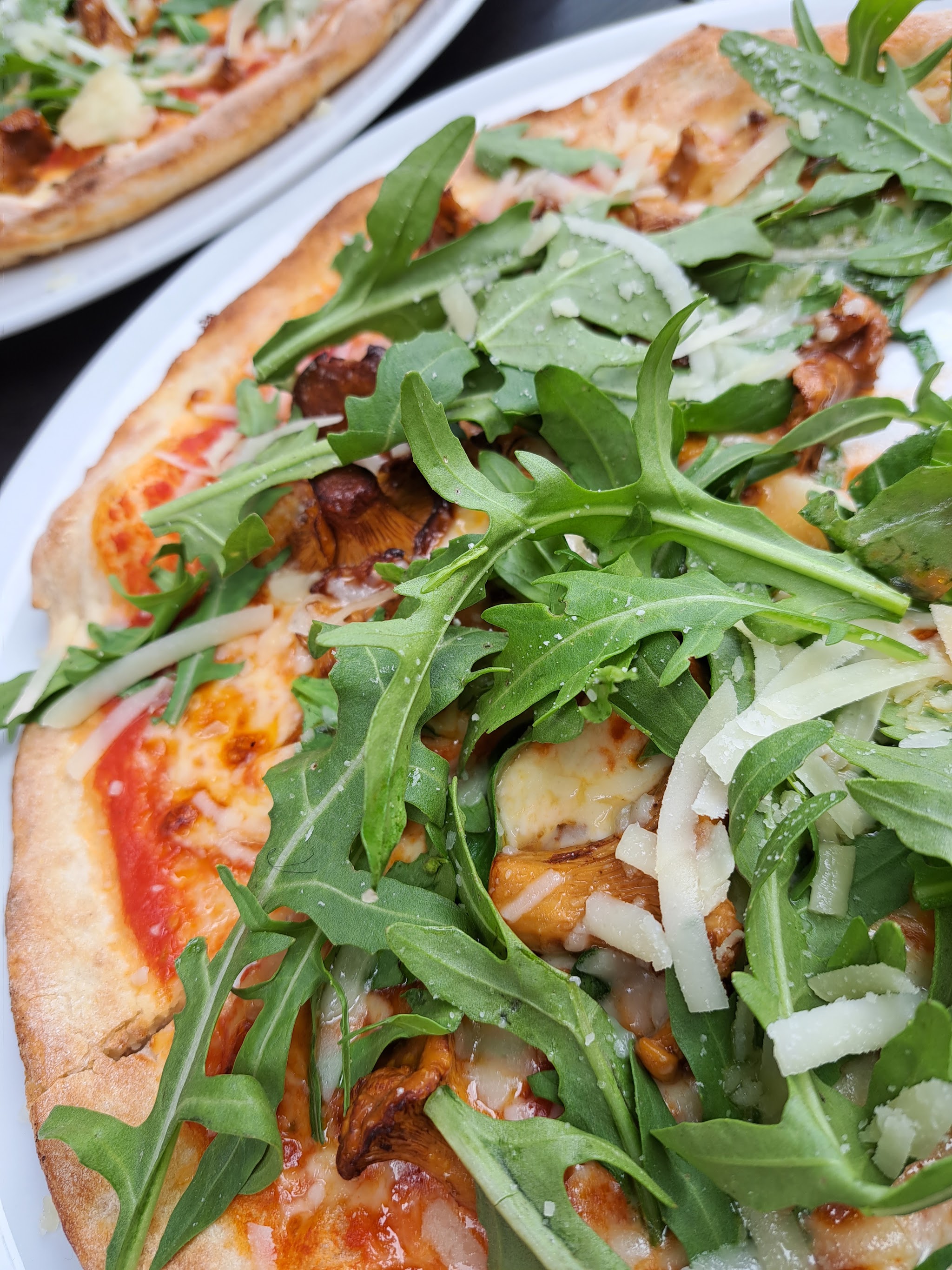 Pizza mit Waldpilzen, Rucola und Parmesan