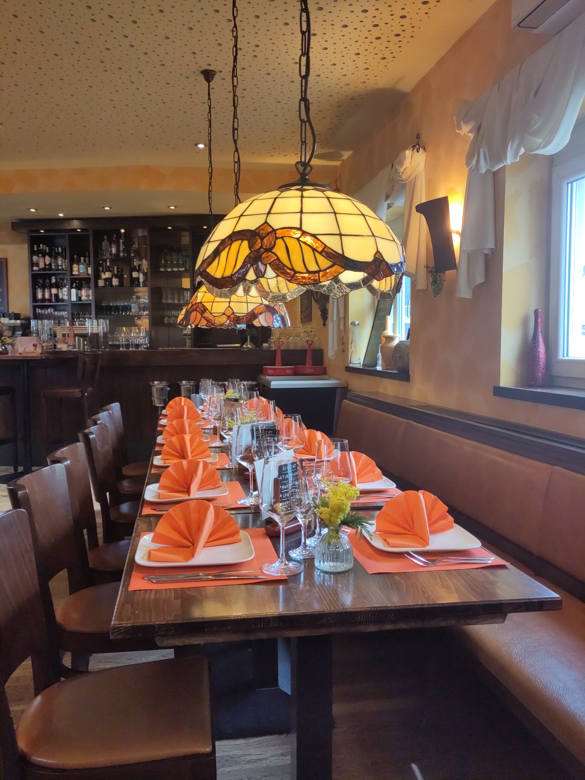 Eingedeckter Tisch bei La Piazza mit Tiffany-Lampe und Weingläsern